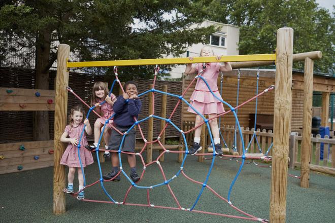 Pupils climbing on a climbing frame in the playground