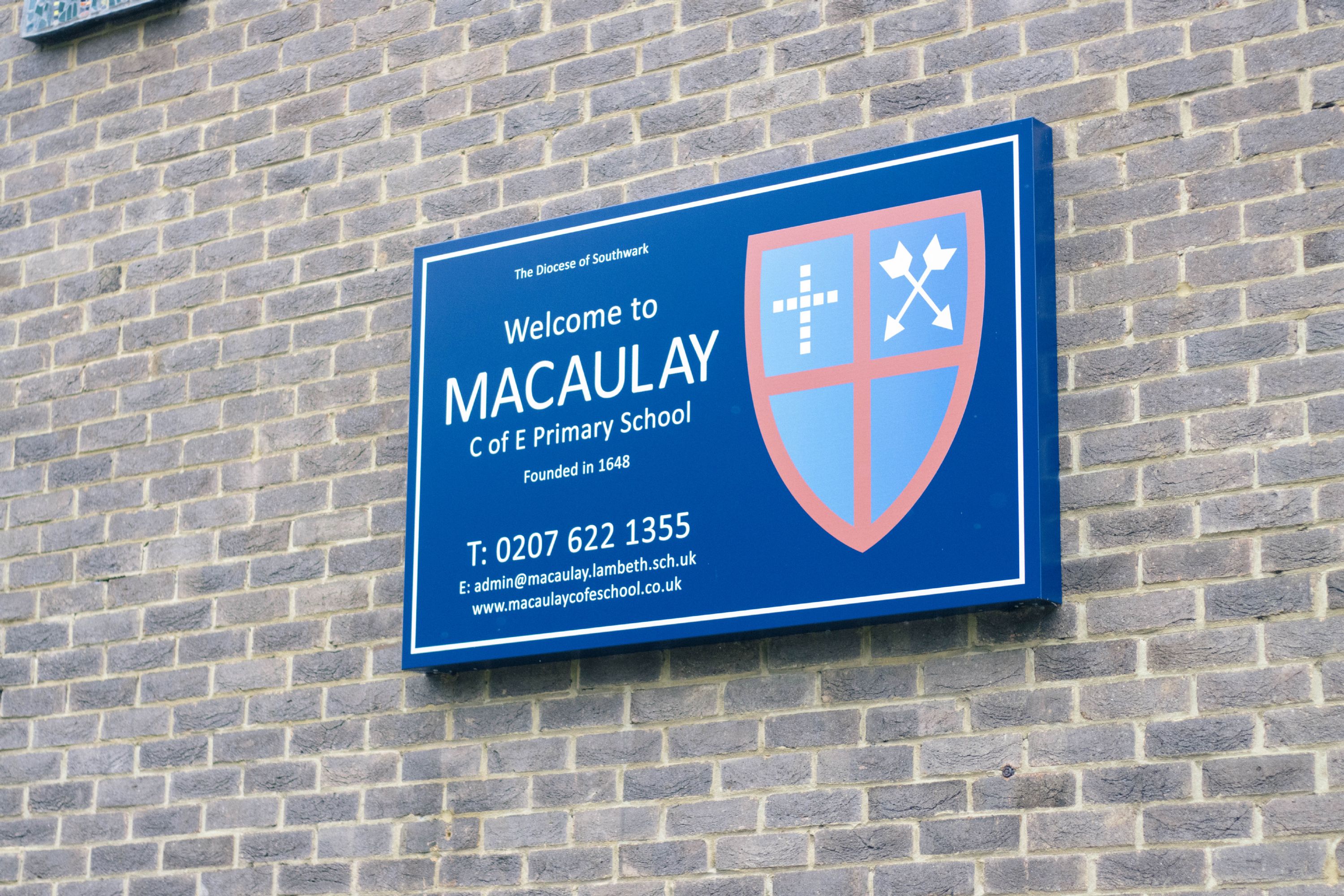 A Macaulay CE Primary School sign on the school building