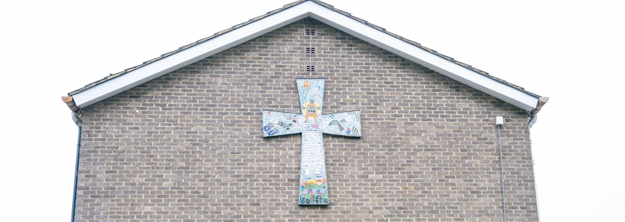 Mosaic cross on exterior wall of the school