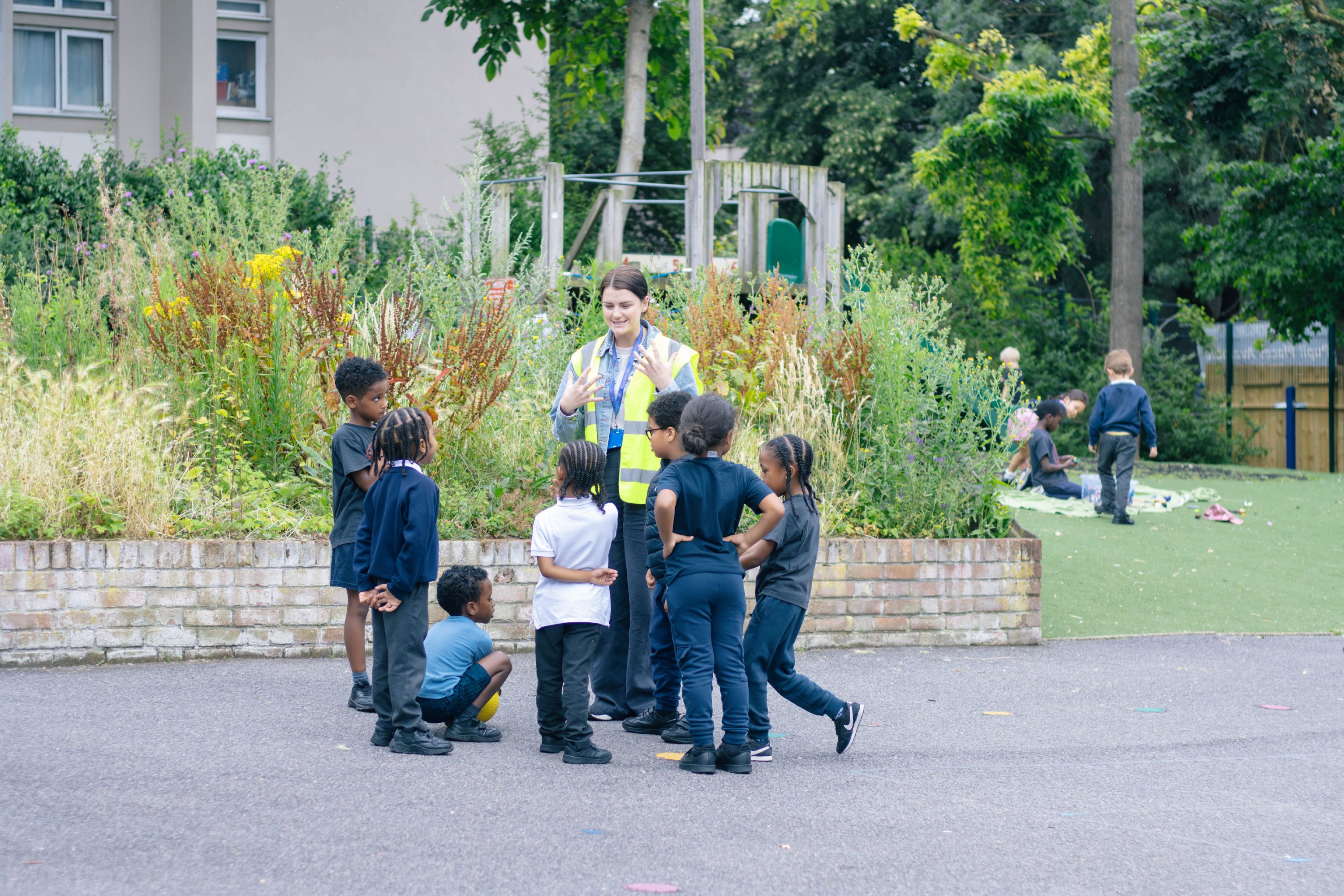 A teacher talking to pupils in the playground